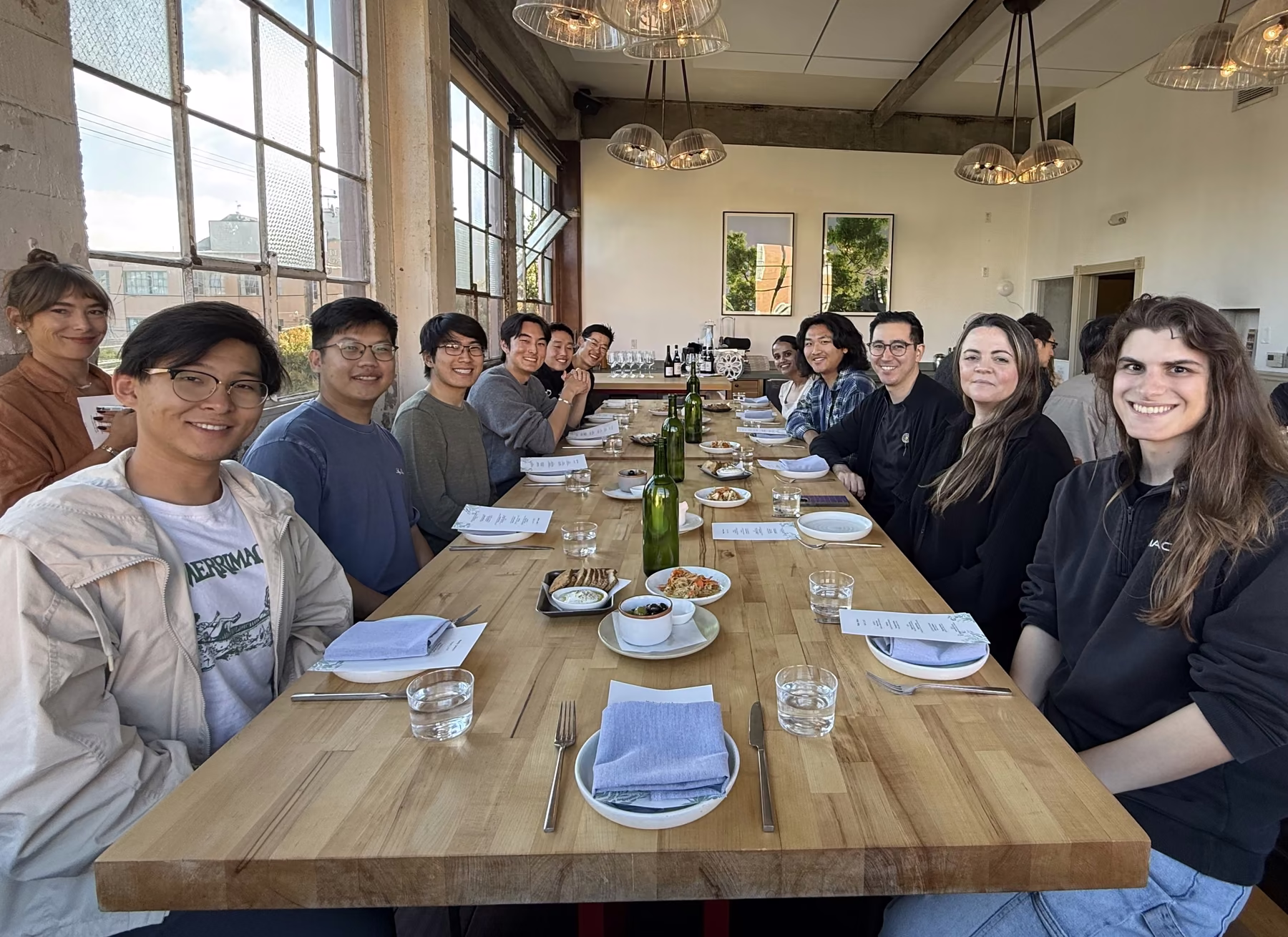 The team seated along a long wooden table at a team dinner